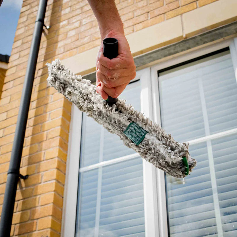 Window cleaner using a complete window washer applicator and sleeve to clean commercial glass windows before squeegee finishing for streak-free results.