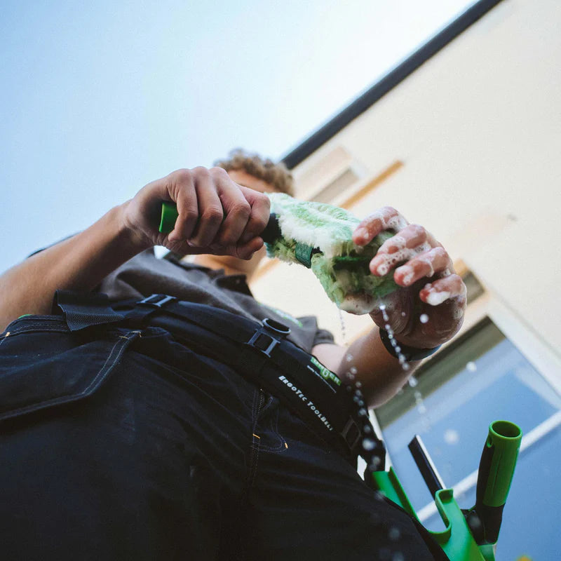 Window cleaner using a complete window washer applicator and sleeve to clean commercial glass windows before squeegee finishing for streak-free results.