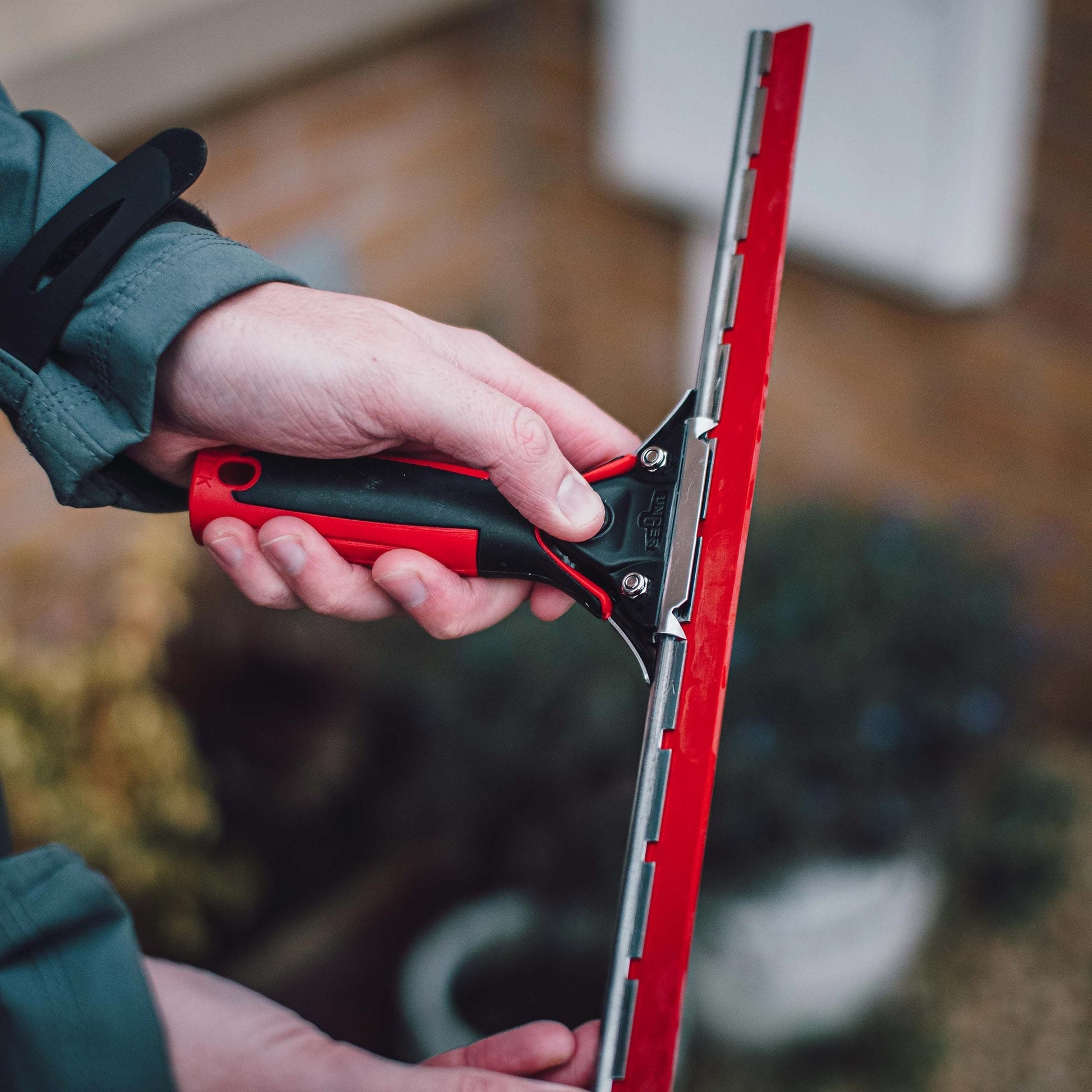 Window Cleaning Red rubber being used by a window cleaning with the facelift handle and channel